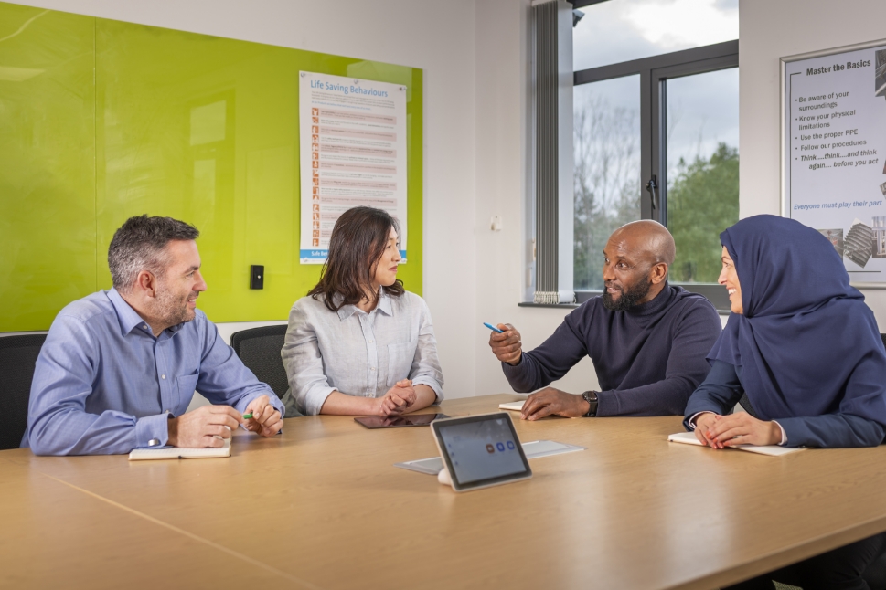 Diverse group of employees sitting around conference table